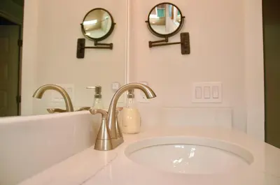 a bathroom with a sink and two mirrors on the wall at Peaceful Shores Retreat in Panama City Beach