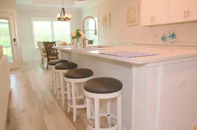a kitchen with a counter with stools at a bar at Peaceful Shores Retreat in Panama City Beach