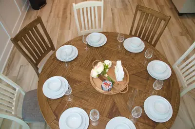 a wooden table with white plates and glasses on it at Peaceful Shores Retreat in Panama City Beach