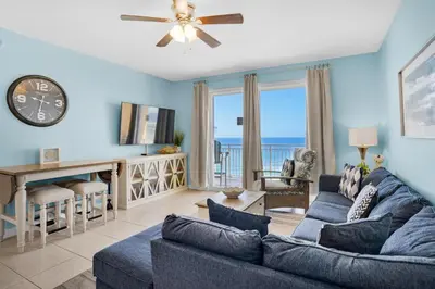a living room with a couch and a clock at Sterling Reef 603 in Panama City Beach