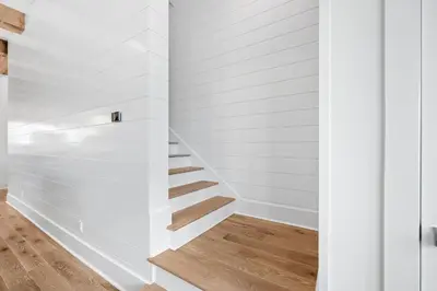 a staircase in a house with white walls and wood floors at Summer Villa - 274 Pompano Street home in Inlet Beach