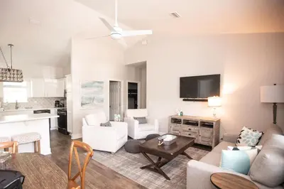 a living room with a couch and a table at Sunset Shenanigans - Easy walk to the beach easy bike ride to Seaside in Santa Rosa Beach