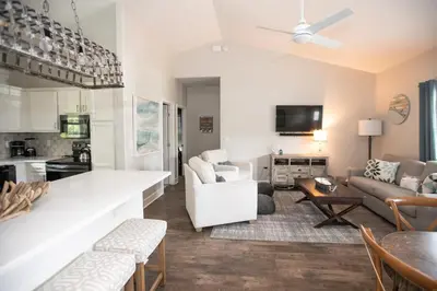 a kitchen and living room with a couch and a table at Sunset Shenanigans - Easy walk to the beach easy bike ride to Seaside in Santa Rosa Beach