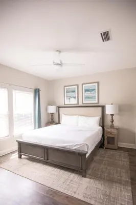 a bedroom with a large white bed with two lamps at Sunset Shenanigans - Easy walk to the beach easy bike ride to Seaside in Santa Rosa Beach