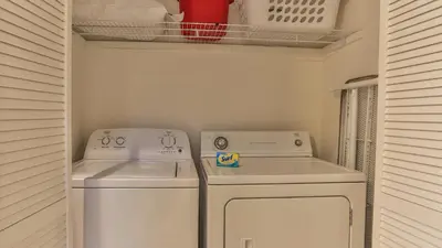 a laundry room with two washing machines and a shelf at After Dune Delight - 3 blocks to the beach less than a mile to Seaside! in Santa Rosa Beach