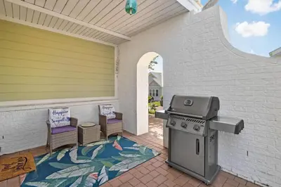 a outdoor patio with a grill and chairs on a patio at 30A Pet Friendly Beach House - Pelican's Rest by Panhandle Getaways in Rosemary Beach