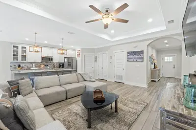 a living room with a couch and a ceiling fan at Pet Friendly Beach House - The Beach Getaway by Panhandle Getaways in Panama City Beach