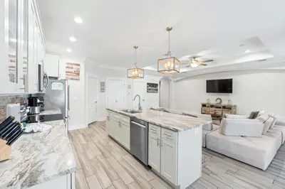 a kitchen and living room with a counter and a couch at Pet Friendly Beach House - The Beach Getaway by Panhandle Getaways in Panama City Beach