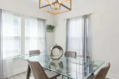 a dining room with a glass table and chairs at Pet Friendly Beach House - The Beach Getaway by Panhandle Getaways in Panama City Beach