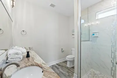 a bathroom with a shower and a sink and a toilet at Pet Friendly Beach House - The Beach Getaway by Panhandle Getaways in Panama City Beach