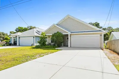 a house with a white garage at Pet Friendly Beach House - The Beach Getaway by Panhandle Getaways in Panama City Beach