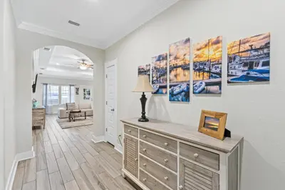 a living room with a dresser with a lamp on it at Pet Friendly Beach House - The Beach Getaway by Panhandle Getaways in Panama City Beach