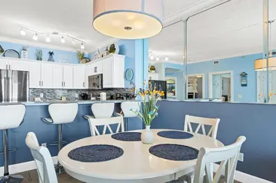 a dining room with a white table and chairs at Twin Palms Beach Resort by Panhandle Getaways in Panama City Beach