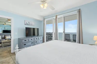 a bedroom with a large bed and a television at Twin Palms Beach Resort by Panhandle Getaways in Panama City Beach