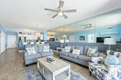 a living room with couches and a ceiling fan at Twin Palms Beach Resort by Panhandle Getaways in Panama City Beach