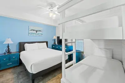 a bedroom with two bunk beds and blue walls at Twin Palms Beach Resort by Panhandle Getaways in Panama City Beach