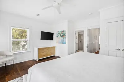 a white bedroom with a bed and a tv at 30A Beach House - Beach Bikin by Panhandle Getaways in Panama City Beach