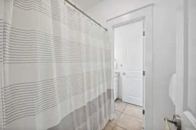 a bathroom with a shower curtain and a toilet at 30A Beach House - Beach Bikin by Panhandle Getaways in Panama City Beach