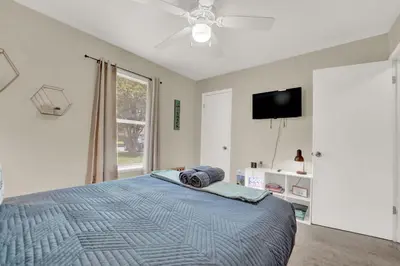 a bedroom with a bed with a ceiling fan and a tv at Two Spaces in One Main House and Guest House 25 Min to PCB in Panama City