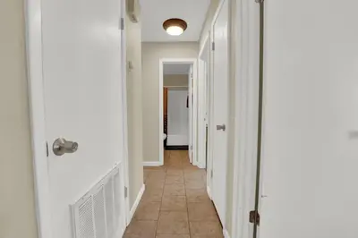 a hallway with white walls and a tile floor at Two Spaces in One Main House and Guest House 25 Min to PCB in Panama City