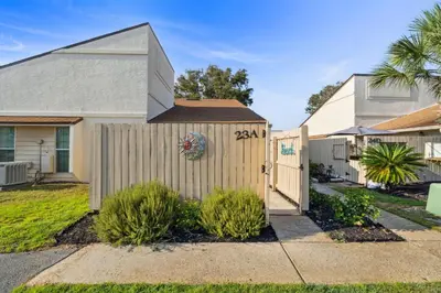a house with a fence in a yard at Horizon South 23A by InJoy Vacations in Panama City Beach