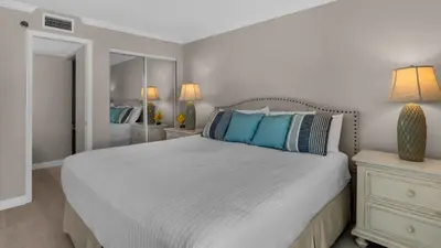 a bedroom with a large bed with blue pillows at BeachCrest 501 in Santa Rosa Beach