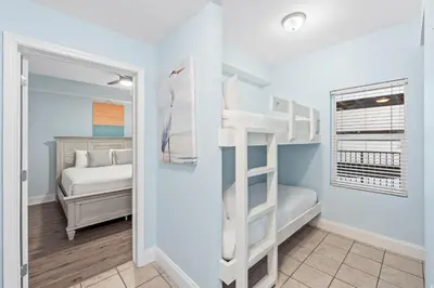 a room with a bunk bed and a bedroom with a bed at Laketown Wharf Resort #238 by Book That Condo in Panama City Beach
