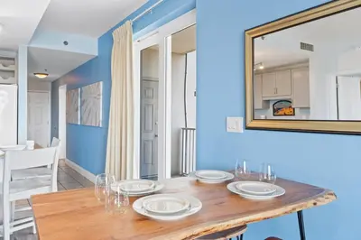a dining room with a wooden table and a mirror at Laketown Wharf Resort #238 by Book That Condo in Panama City Beach