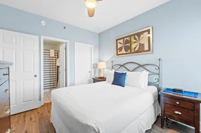 a bedroom with a white bed and blue walls at Laketown Wharf Resort #238 by Book That Condo in Panama City Beach