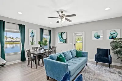 a living room with a blue couch and a table at NEW ⁂Serenity Beach⁂ Lakefront 3BRs Close to Beach in Panama City Beach