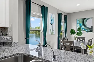 a kitchen with a sink and a dining room with a window at NEW ⁂Serenity Beach⁂ Lakefront 3BRs Close to Beach in Panama City Beach