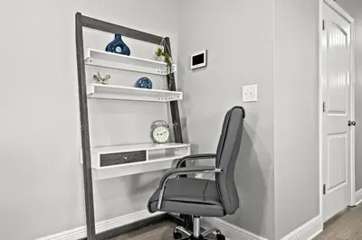 a chair in a room with white shelves and a mirror at NEW ⁂Serenity Beach⁂ Lakefront 3BRs Close to Beach in Panama City Beach