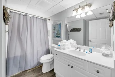 a white bathroom with a toilet and a sink at Emerald Beach 431 in Panama City Beach