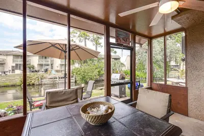 a dining room with a table and some windows at PCB Townhome with Resort Amenities - Walk to Ocean! in Panama City Beach