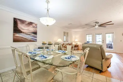 a dining room with a glass table and chairs at PCB Townhome with Resort Amenities - Walk to Ocean! in Panama City Beach