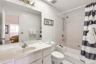 a white bathroom with a sink and a toilet at PCB Townhome with Resort Amenities - Walk to Ocean! in Panama City Beach