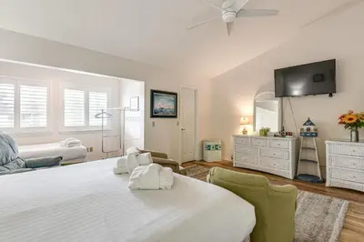 a bedroom with a large bed and a flat screen tv at PCB Townhome with Resort Amenities - Walk to Ocean! in Panama City Beach