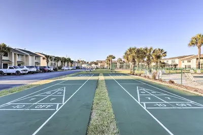 a tennis court in a residential street with palm trees at PCB Townhome with Resort Amenities - Walk to Ocean! in Panama City Beach