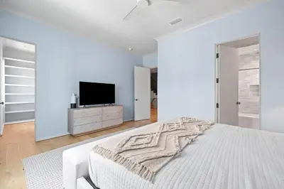 a white bedroom with a bed and a tv at Verisun - 40 Elysee Court home in Inlet Beach