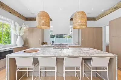 a kitchen with a large island with white chairs at Verisun - 40 Elysee Court home in Inlet Beach