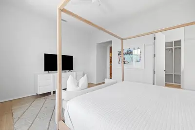 a white bedroom with a white bed and a tv at Verisun - 40 Elysee Court home in Inlet Beach