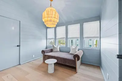 a living room with a couch and a chandelier at Verisun - 40 Elysee Court home in Inlet Beach