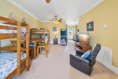 a living room with bunk beds and a dining room at Summer Special, Lux 4BR House Sleeps 12, Pool, Elevator, King bed in Panama City Beach