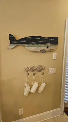 a fake fish hanging on a wall with four bags at Summer Special, Lux 4BR House Sleeps 12, Pool, Elevator, King bed in Panama City Beach