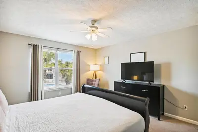 a bedroom with a bed and a flat screen tv at Babberville 11818 By Book That Condo in Panama City Beach