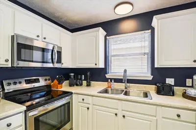 a kitchen with white cabinets and a sink at Babberville 11818 By Book That Condo in Panama City Beach