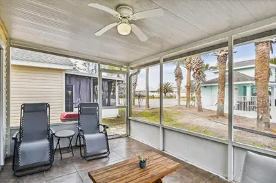 a screened porch with a table and chairs and windows at Babberville 11818 By Book That Condo in Panama City Beach