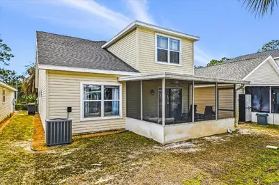 a yellow house with a yard at Babberville 11818 By Book That Condo in Panama City Beach