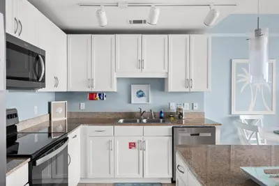 a kitchen with white cabinets and a sink at Remodeled Resort Condo! Ocean & Beach Views by Dolce Vita Getaways PCB in Panama City Beach