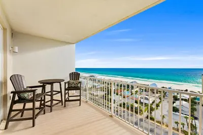 a balcony with two chairs and a table and the ocean at Remodeled Resort Condo! Ocean & Beach Views by Dolce Vita Getaways PCB in Panama City Beach